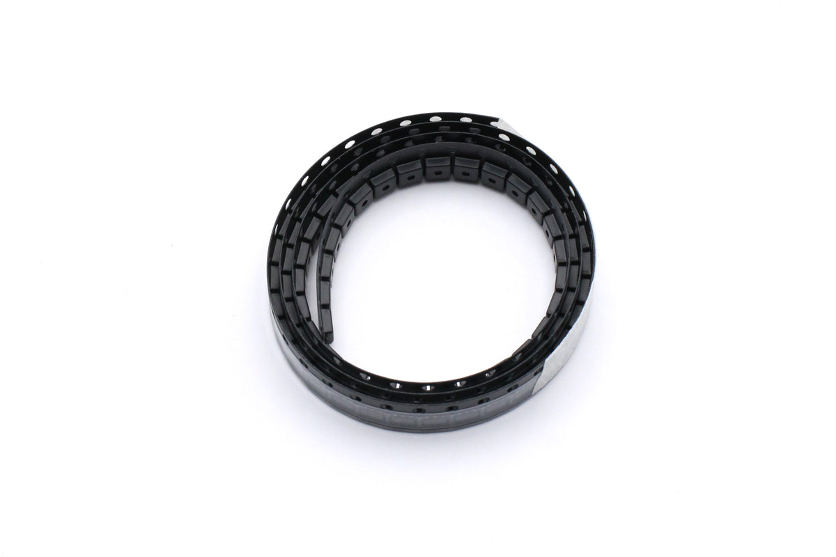 PADAUK PMS150C-U06 microcontrollers in coiled black cut-tape packaging on a white background