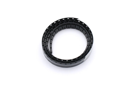 PADAUK PMS150C-U06 microcontrollers in coiled black cut-tape packaging on a white background